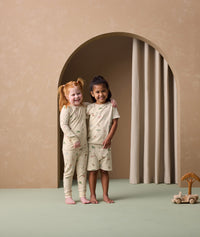 Two preschoolers are wearing ergoPouch two-piece pyjamas Savannah. The child on the left is in long sleeve pyjamas, while the child on the right is in short sleeve ones.