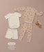 Flat lay of a cream Short Sleeve Pyjama set and a beige Long Sleeve Pyjama set with a wooden toy horse and feature text callout.