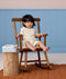 Toddler wearing cream patterned Short Sleeve Pyjamas sitting on a wooden chair.