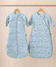 The Jersey Sleeping Bag and Side Zip Sleeping Bag hang side by side on wooden hangers. Both are light blue with small dragonflies pattern; the Jersey Sleeping Bag has a center front zipper, while the Side Zip Sleeping Bag features a diagonal side zipper.