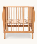 Wooden cot with a minimalist design on a white background