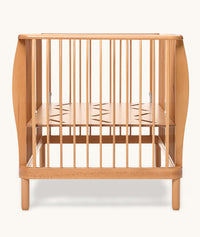 Wooden cot with a minimalist design on a white background