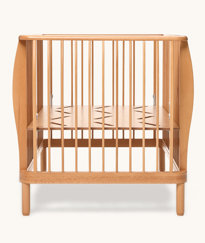 Wooden cot with a minimalist design on a white background