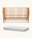 Wooden cot and mattress on a white background