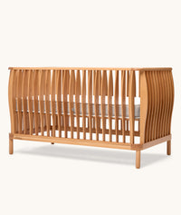 Wooden cot with slatted design on a white background
