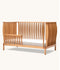 Wooden cot with a slatted design on a white background
