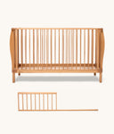Wooden cot with a separate sideguard on a white background