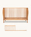 Wooden cot with a separate sideguard on a white background