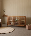 Wooden cot in a nursery with neutral decor