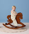 Toddler riding a wooden rocking horse wearing a sleeveless cream printed Sleep Suit Bag.