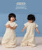 Toddler wearing cream convertible sleep suit bag, demonstrating the bag mode on the left and separate legs mode on the right.