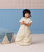 Toddler standing while wearing a cream patterned short-sleeve Sleep Suit Bag.