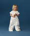 Toddler standing against a blue background wearing a white Sleep Suit Bag 1.0 TOG Daydream, featuring short sleeves and colourful all-over print
