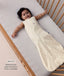 Baby lying in a wooden cot, wearing a sleeveless cream sleeping bag with text highlighting 