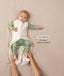 A baby lying down in a green long sleeve layer with an unzipped oatmeal-coloured sleeping bag while adult hands hold their feet. Text highlighting 