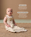 Baby wearing a sleeveless, patterned sleep sack sits on a woven rug, accompanied by product feature callouts for 