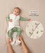 A baby lying down in a green long sleeve layer with an unzipped beige sleeping bag while adult hands hold their feet. Text highlighting 