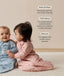 Two babies wearing long-sleeved sleeping bag sit on a carpet. Next to them, text highlights features including 