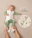 A baby lying down in a green long sleeve layer with an unzipped beige sleeping bag while adult hands hold their feet. Text highlighting 