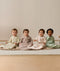 Four infants sitting side-by-side wearing ergoPouch Sleeping Bag 1.0 TOG Sleeved in Savannah, Taupe Marle, Coastal, and Meadow.