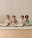 Four infants sitting side-by-side wearing ergoPouch Sleeping Bag 1.0 TOG Sleeved in Savannah, Taupe Marle, Coastal, and Meadow.