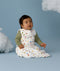 Baby wearing a white Sleeping Bag 2.5 TOG with colourful all-over print, sitting against a light blue background with decorative clouds.