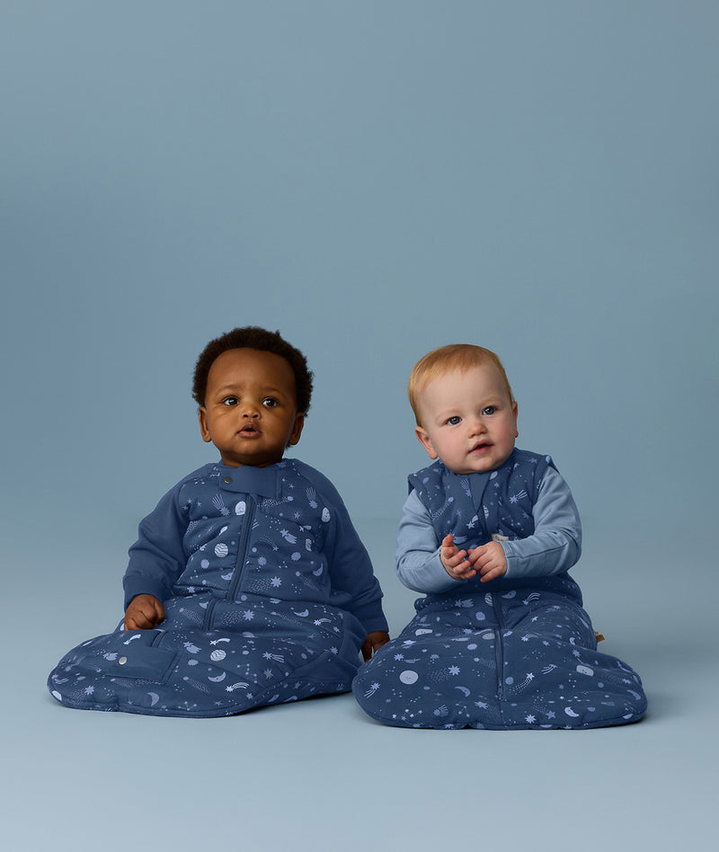 Two infants sitting side by side wearing  Premium Sleeping Bag 3.5 TOG and Jersey Sleeping Bag 2.5 TOG in Starbeam colourway.