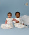 Two babies wearing ergoPouch sleeping bags. One baby wears a Premium Sleeping Bag 2.5 TOG while the other baby is wearing a 3.5 TOG Jersey Sleeping Bag.