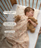 Sleeping toddler resting on a patterned organic cotton toddler pillow, with text highlighting breathable material, ideal height, and cot-to-bed transition features.