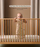 Child standing inside a wooden cot with text about non-toxic beechwood.