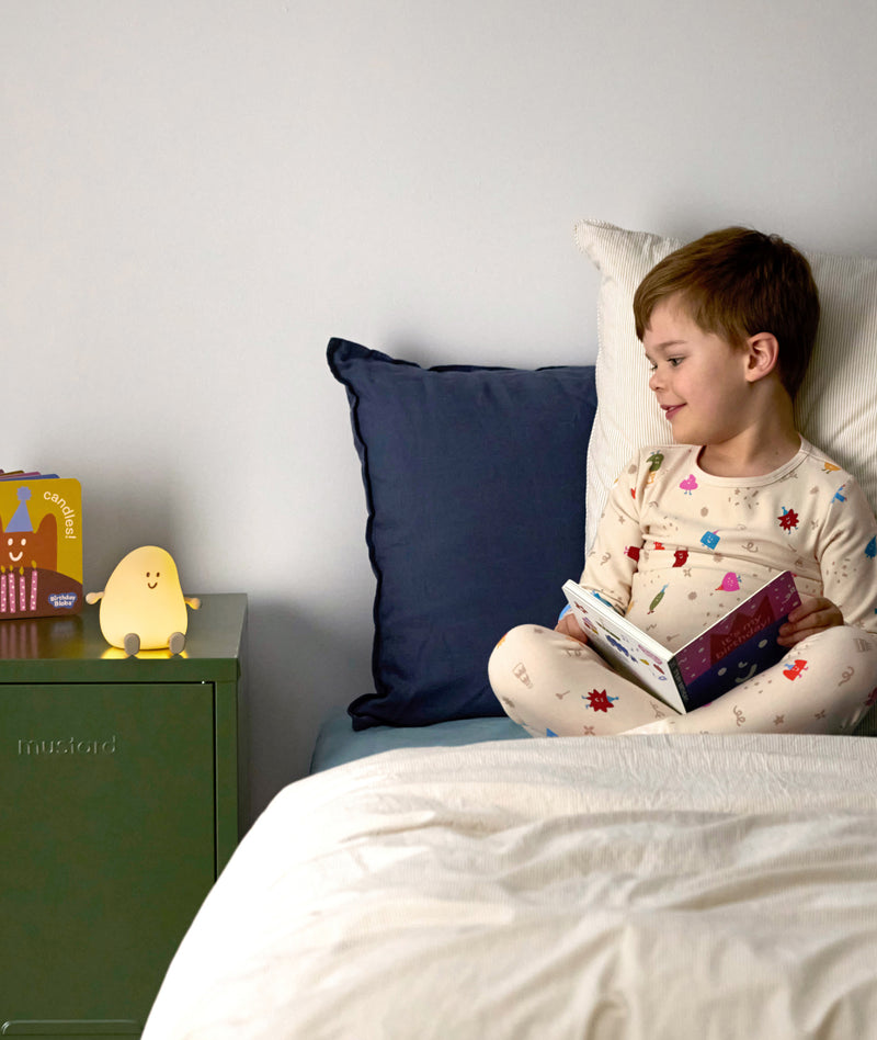 Blobby Bedtime Lamp Taupe sitting on bedside table next to kid