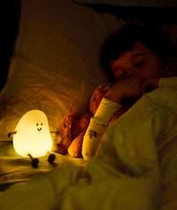 Blobby Bedtime Lamp Taupe yellow light setting with child sleeping in dark room
