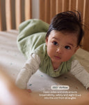 Baby in a green outfit lying on a cot with text about '360° Airflow'.