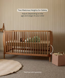 Wooden cot with mattress in a nursery setting, emphasizing safety and adjustability.