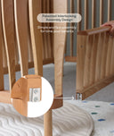 Wooden cot with interlocking design feature and text about assembly simplicity.