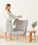 Mum wears a comfortable bamboo pregnancy robe, holding an ergoPouch Cocoon Swaddle Bag