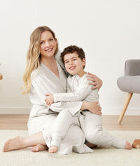 Mum wearing ergoPouch Matchy Matchy Robe in Grey Marle cuddles with son in matching Sleep Onesie