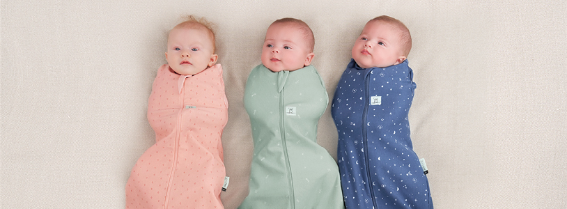 Three babies wearing ergoPouch swaddle bags for safe sleep