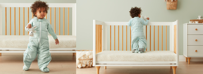 Toddler standing up in cot, holding onto railings