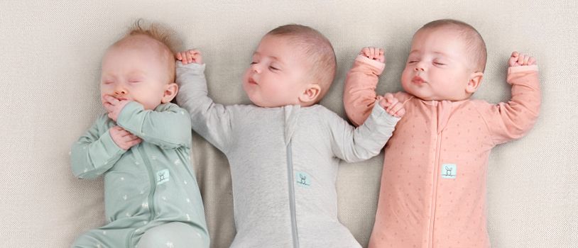 Three infant babies sleeping side by side