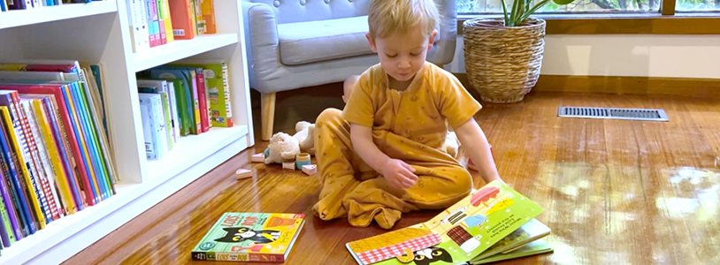 Boy sitting on the floor, reading to himself, instead of screen-time before bed