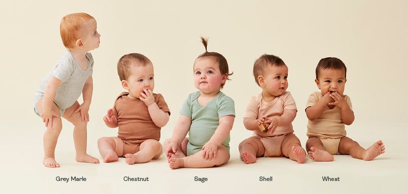 Infant babies sitting up wearing different ergoPouch short sleeve bodysuits