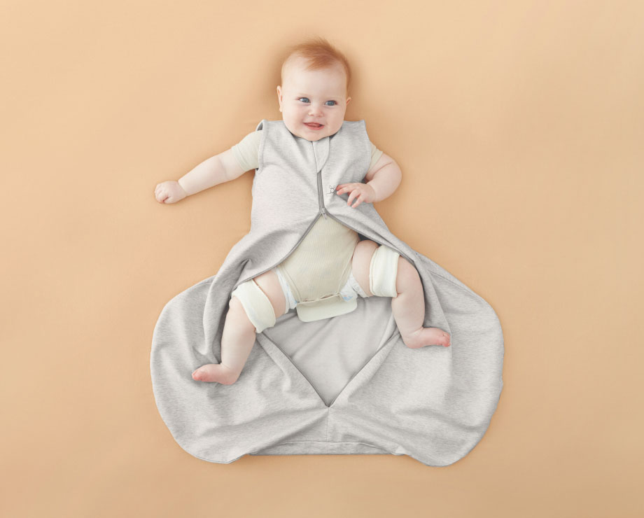 Baby with hip dysplasia wearing sleeping bag with zipper open