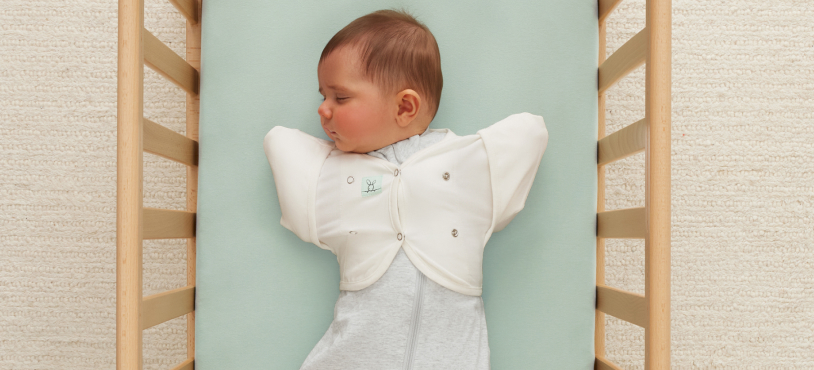 Baby wearing Butterfly Cardi to transition arm positions